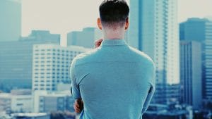 Business man back towards camera facing city skyline