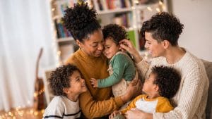 lesbian couple with 3 kids sitting in the living room