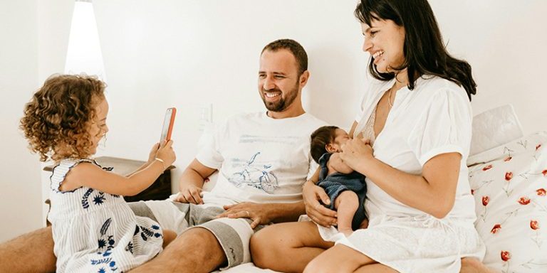 couple with two small kids, happy at home after changing lenders at mortgage renewal.