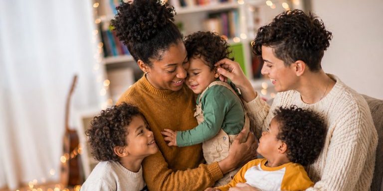 lesbian couple with 3 kids sitting in the living room