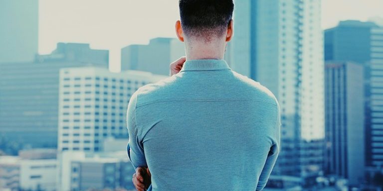 Business man back towards camera facing city skyline